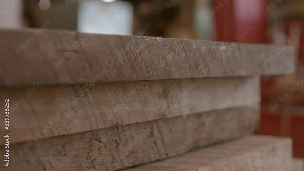 Lumber boards in a stack in a workshop, close up with slow track left Lumber boards in a stack in a workshop, close up with slow track left