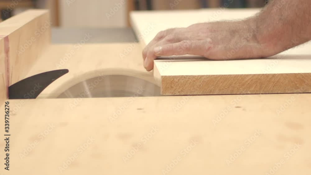 Craftsman cuts wood boards with table saw in slow motion close up Craftsman cuts wood boards with table saw in slow motion close up