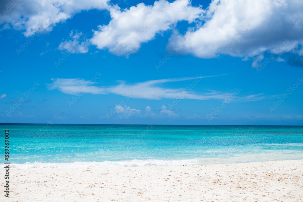 white sand beach on a blue sky with white clouds