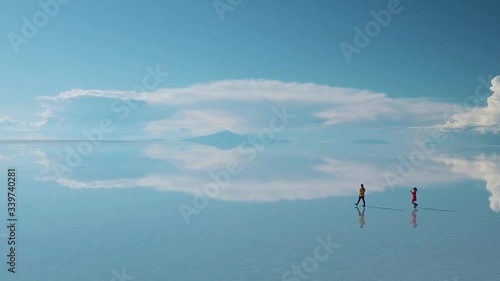 Drone footage of two people walking at Salar de Uyuni Salt Flat, Bolivia