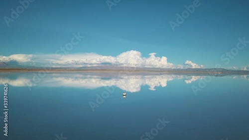 Drone Footage of a car driving at Salar De Uyuni salt flat just before sunset, Blue Hour