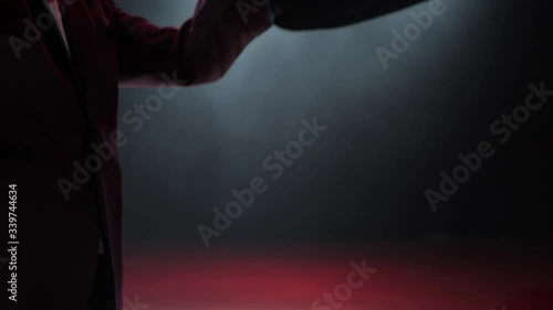 Magician is straightening his hat and twisting it in his hands. Close-up.