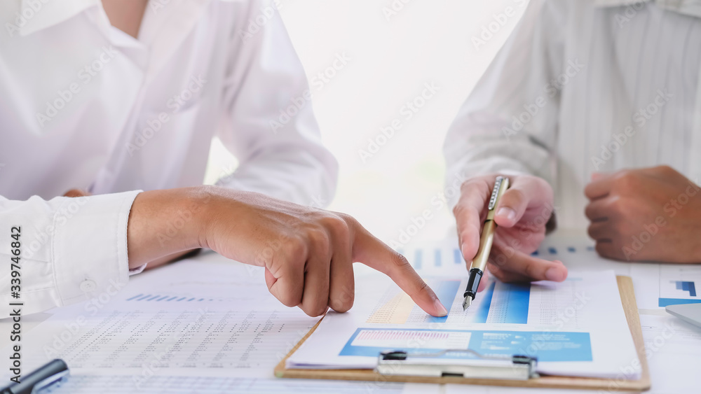 Asian business people meeting with new startup project pointing graph discussion and analysis data charts and graphs.Business finances and accounting concept Asian business people meeting with new startup project pointing graph discussion and analysis data charts and graphs.Business finances and accounting concept