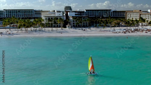 Catamaran sailing off the beach in Punta Cana, Dominican Republic, luxury tropical vacation and holiday resort in the background, romantic getaway in the Caribbean sea photo