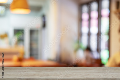 Empty wooden table blurred of restaurant cafe background and reception room, can be used for display or montage your products
