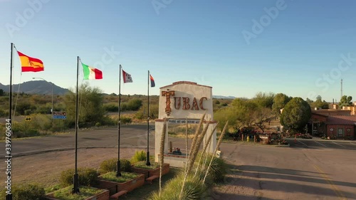Flying Towards The Tubac Sign With Different Flags On The Pole Swaying On The Wind In Tubac Arizona, USA.-  aerial drone shot photo