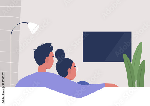 A couple watching TV at home, weekend relaxation, modern lifestyle