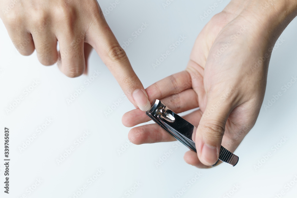 Man using nail clipper clipping her fingernails. white background