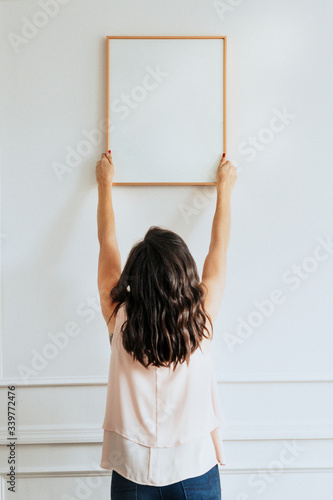 фотографія Woman hanging a frame