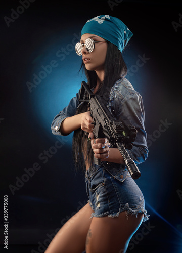 a girl in a DENIM jacket with an AUTOMATIC RIFLE