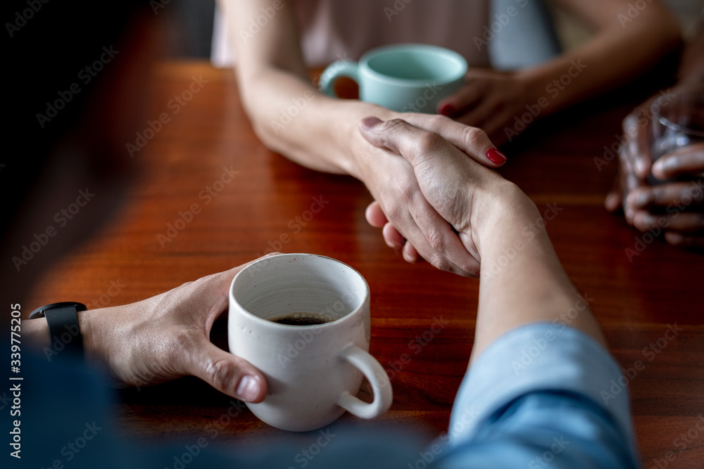 People shaking hands over coffee People shaking hands over coffee