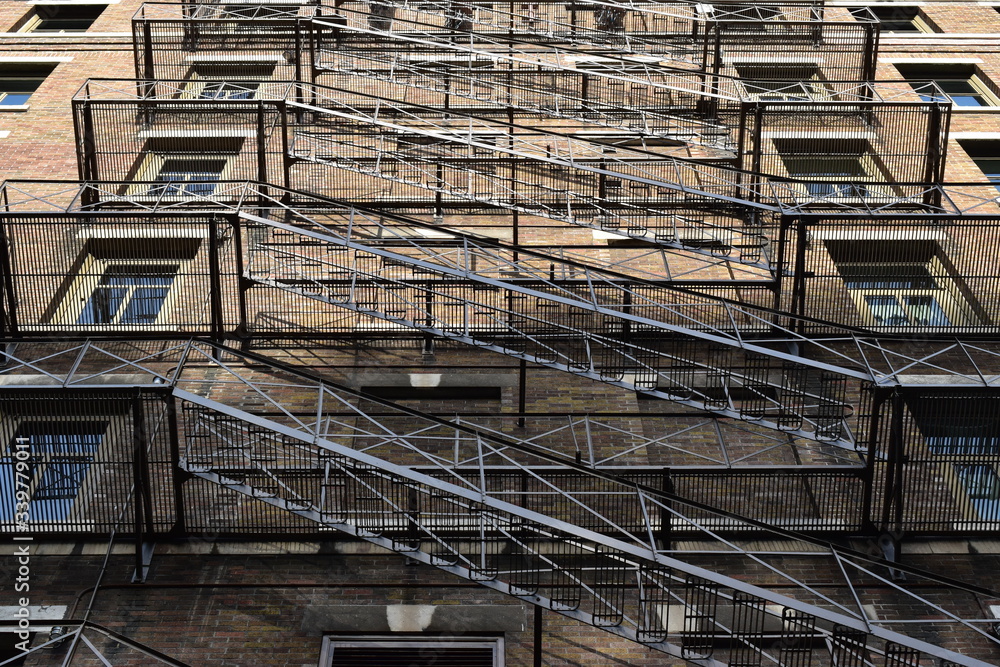 Emergency Fire Escape staircase on the back side of a brick building. Fire exit, north american icon. Emergency Fire Escape staircase on the back side of a brick building. Fire exit, north american icon.