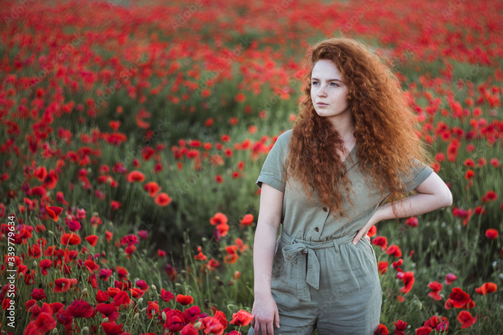 Young beautiful red-hear girl in red poppy field Young beautiful red-hear girl in red poppy field