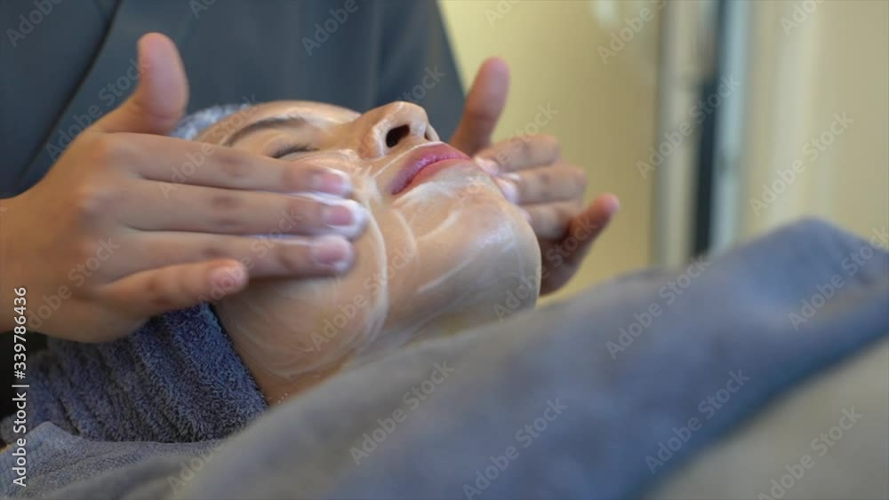 Woman clean skin of the face and receiving massage. Anti aging treatment and plastic surgery concept Woman clean skin of the face and receiving massage. Anti aging treatment and plastic surgery concept