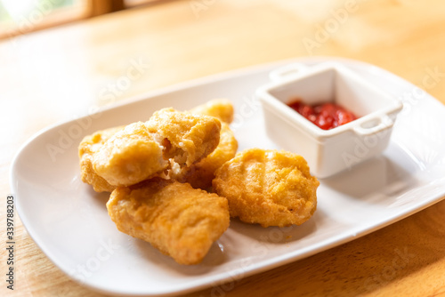 chicken nuggets on white plate with ketchup