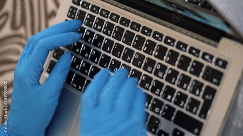 Isolated medic student wear protective medical blue gloves, write dissertation, use laptop, type text. Learning lessons distantly self-isolating at home close up top view. Pandemic by corona virus flu photo