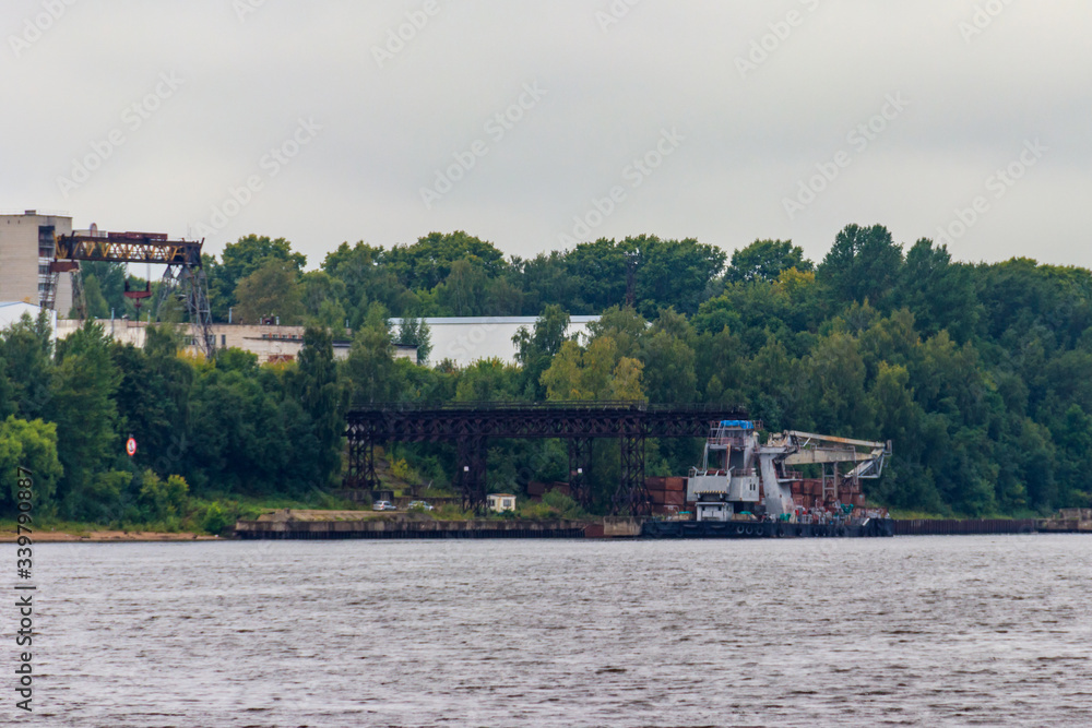 Floating Construction crane on a platform near the shore of the Volga river in Russia