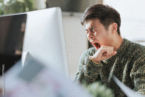 Sleepy office worker at his workstation photo