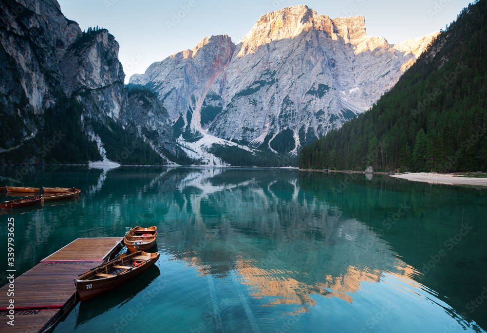 Emerald Mountain Lake Braies. boat station. Wooden pier. Morning landscape in Italy