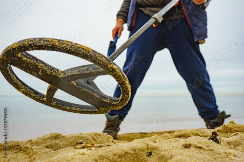 Schilderij op canvas Man with metal detector on sea beach