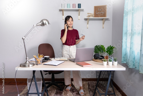 Pensive asian woman is relaxing on  desktop working remotely from home with laptop for communicates on internet with customer  E learning learn teach in online chat  quarantine Coronavirus concept.