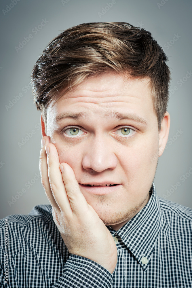 a young man feels toothache