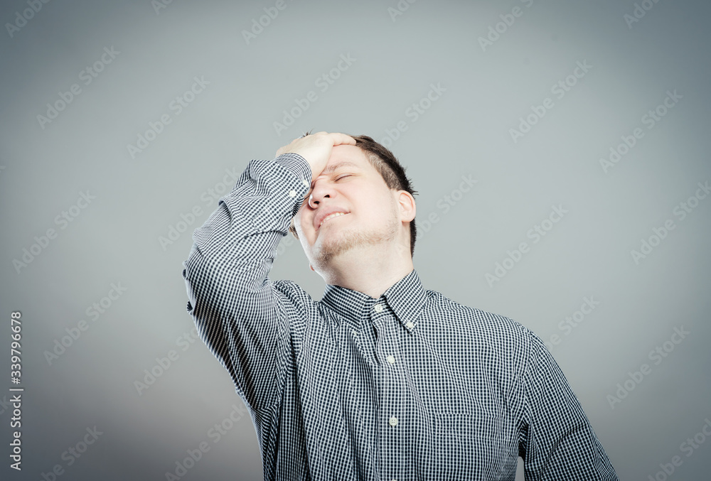 Closeup portrait of a upset young man with hand on his head