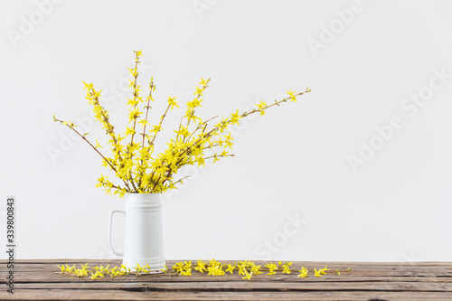 Fototapeta Naklejka Na Ścianę i Meble -  spring yellow flowers in white jug on white background