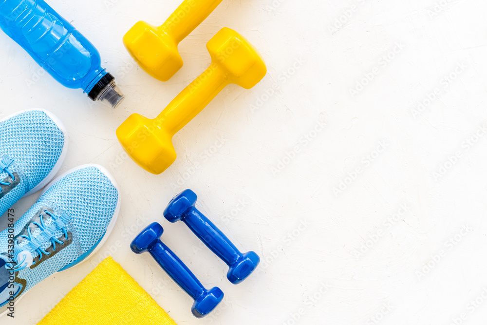 workout accessories. Sneakers, dumbbells, towel on white background top view copy space workout accessories. Sneakers, dumbbells, towel on white background top view copy space