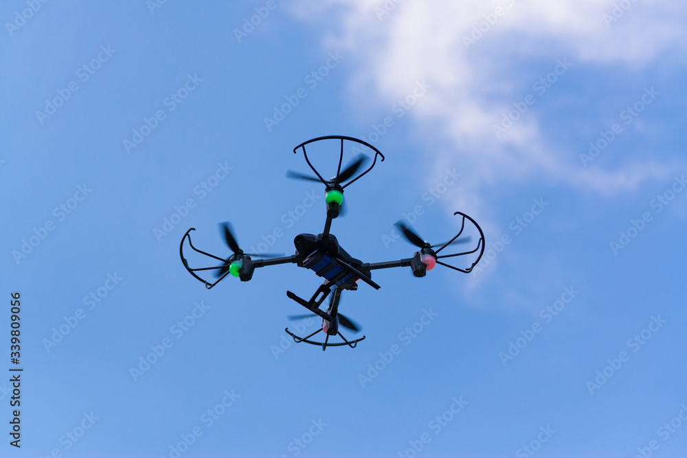 Flying drone of quad copter in blue sky. Flying drone of quad copter in blue sky.