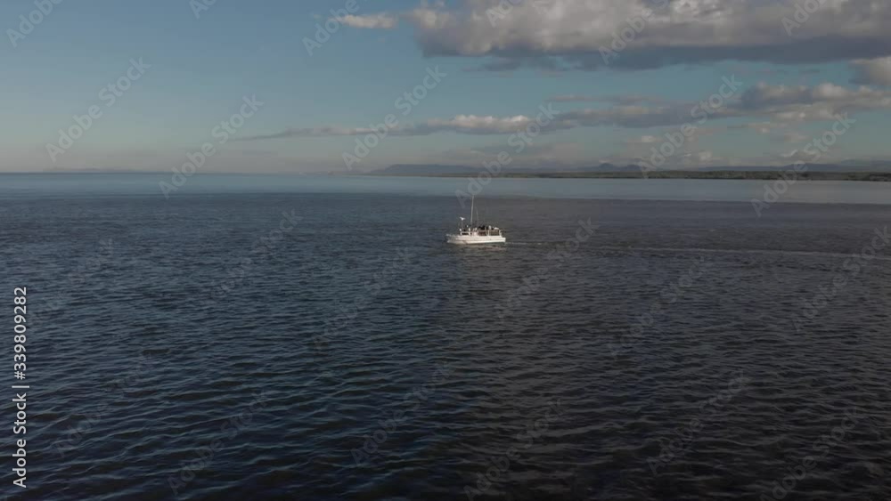 A White Speed Boat Cruising On The Deep Blue Sea At Costa Rica Under The Blue Sky. - aerial drone shot A White Speed Boat Cruising On The Deep Blue Sea At Costa Rica Under The Blue Sky. - aerial drone shot