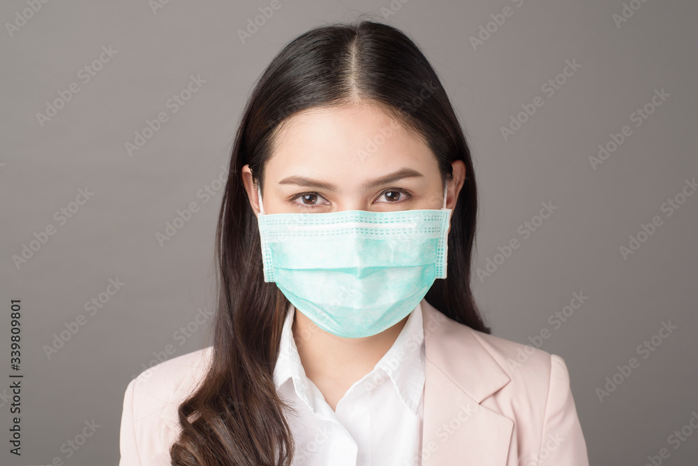 close up portrait of business woman with surgical mask on gray background close up portrait of business woman with surgical mask on gray background