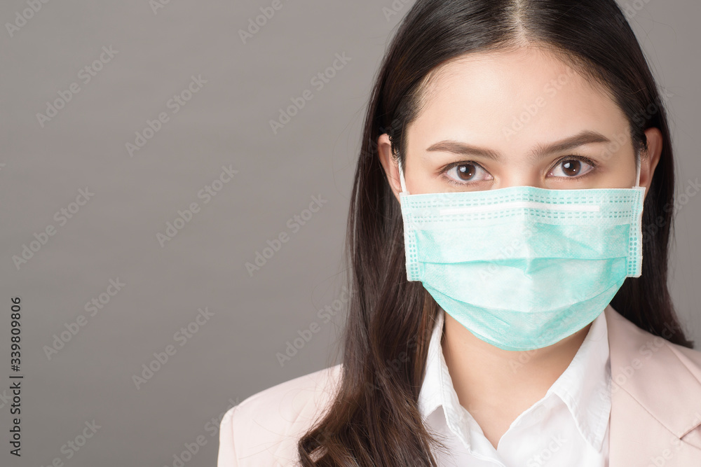 close up portrait of business woman with surgical mask on gray background close up portrait of business woman with surgical mask on gray background