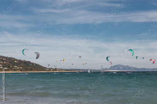 People are practicing kitesurf in the sea.