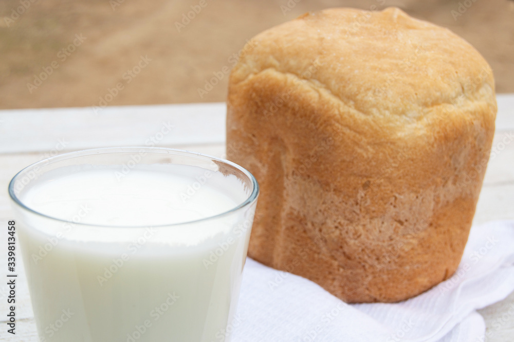 Fresh homemade bread and a glass of natural homemade organic yogurt on a white wooden background. Fresh homemade bread and a glass of natural homemade organic yogurt on a white wooden background.