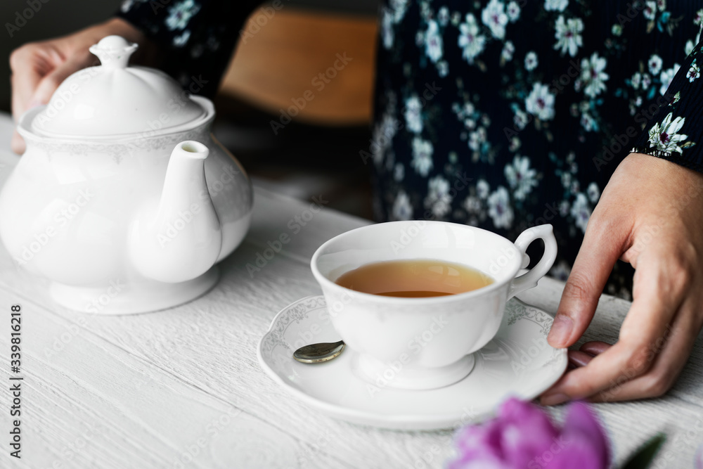 Woman helping herself with a cup of nice hot tea Woman helping herself with a cup of nice hot tea