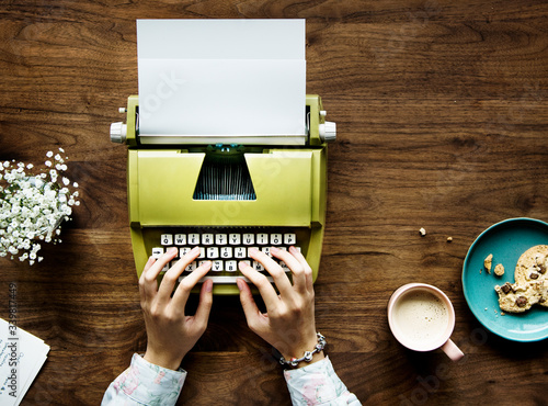 Принти на полотні Aerial view of a woman typing on a retro typewriter blank paper