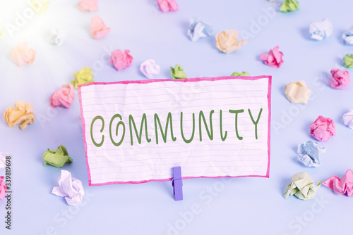 Conceptual hand writing showing Community. Concept meaning group of showing with a common characteristics living together Colored crumpled papers empty reminder blue floor clothespin photo