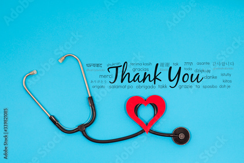 Thanks message worldwide postcard background in different languages for nhs staff, doctors, nurses. Novel coronavirus, covid 2019 thanking note with stethoscope, thank you card with copy space