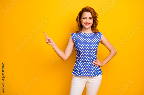 Portrait of positive cheerful woman point index finger copyspace indicate ads promo present feedback wear pin-uppinup blouse isolated over bright color background