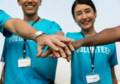 Team of volunteers stacking hands photo