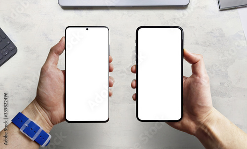Canvas Print Man hand comparing two new smartphone