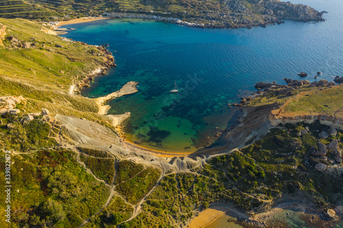 Aerial top view of famous Ghajn Tuffieha beach and hills. Sunset time, nature landscape. Malta 