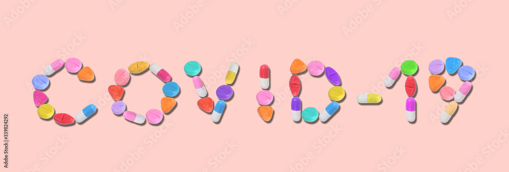 miniature blue drug model arrange in word (covid - 19) on pastel background