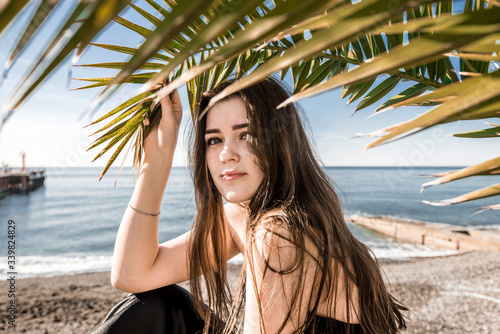 girl on the beach under a palm tree © Maksim