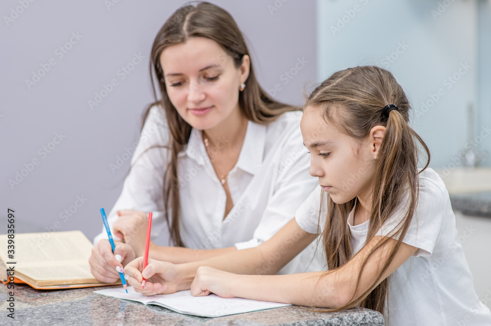 Mom checks her daughter's homework at home Mom checks her daughter's homework at home