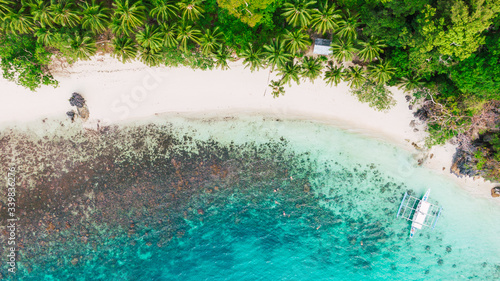 People snorkelling in an island near a tropical coral reef. El Nido, Palawan, Phillipines.