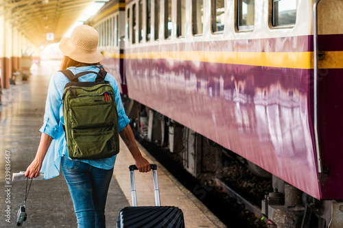 Solo woman backpacker traveler plan safety trip low cost budget summer holiday after coronavirus. Empty tourists on train railway platforms. Use bus train sustainable environmental friendly transport