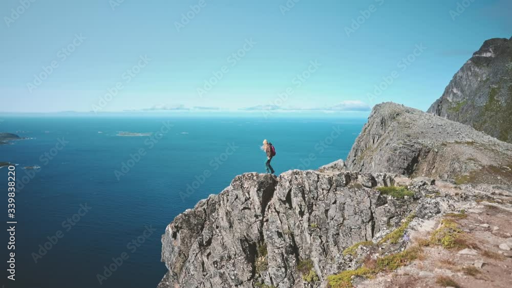 Woman traveler on mountain cliff edge alone travel hiking in Norway adventure active vacations healthy lifestyle backpacking landscape ocean aerial view Woman traveler on mountain cliff edge alone travel hiking in Norway adventure active vacations healthy lifestyle backpacking landscape ocean aerial view