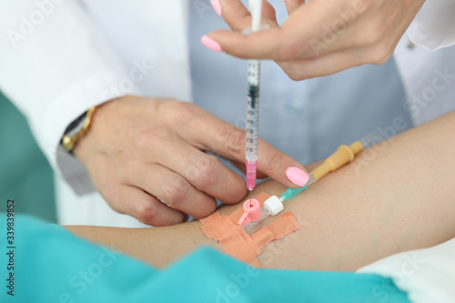Female doctor injects medicine into patients vein. Medical care in hospital is provided with assistance specialized specialists. Preoperative preparation. Appearance allergic reactions